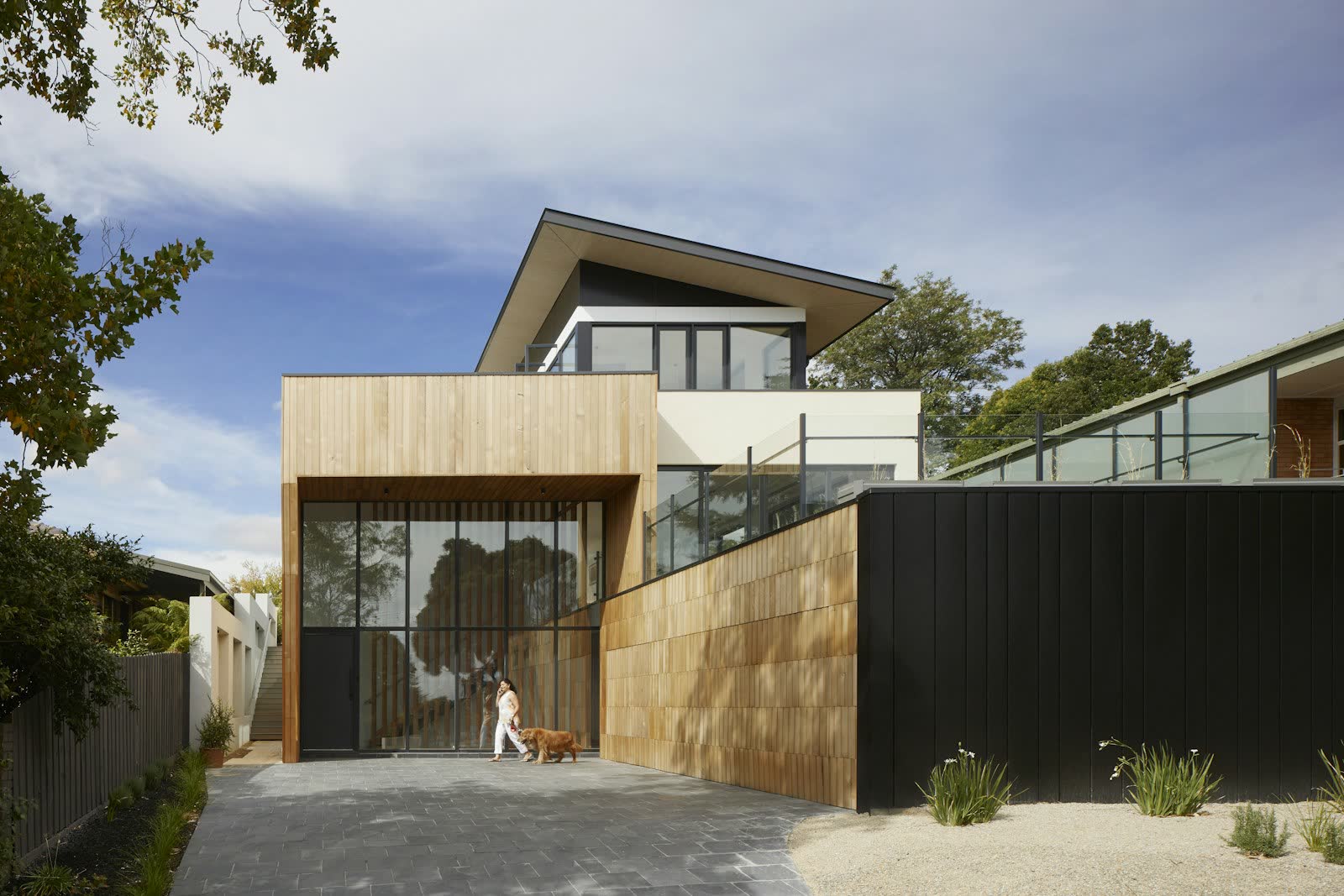 Contemporary timber-clad family house with a cantilevered upper floor